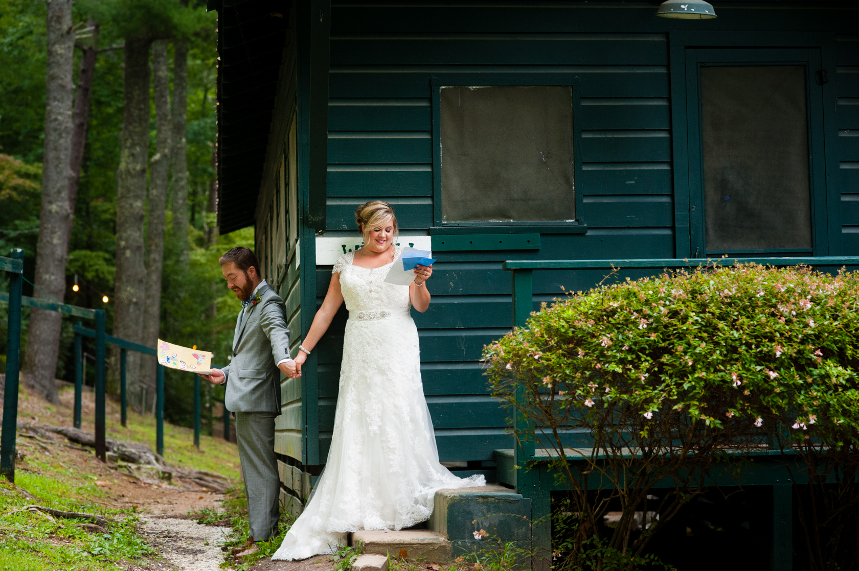 bride and groom hold hands around the corner of a mountain cabin