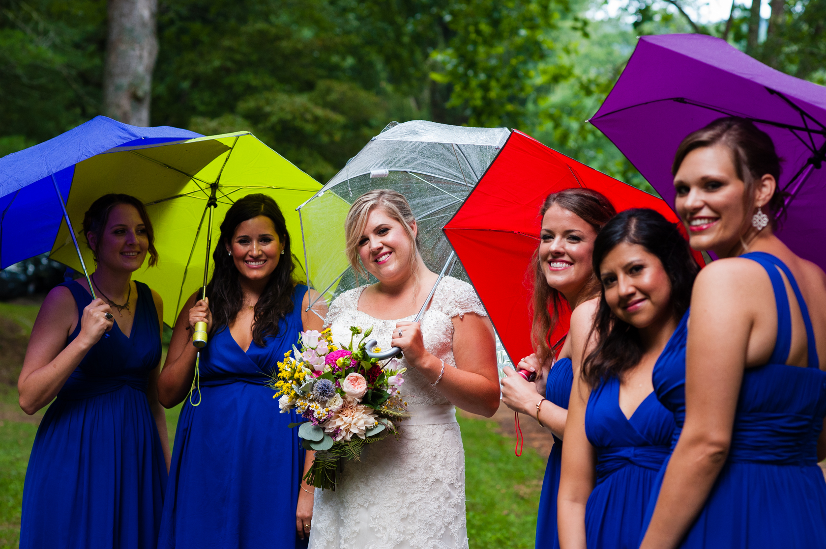 gorgeous bride and her ladies holding umbrellas