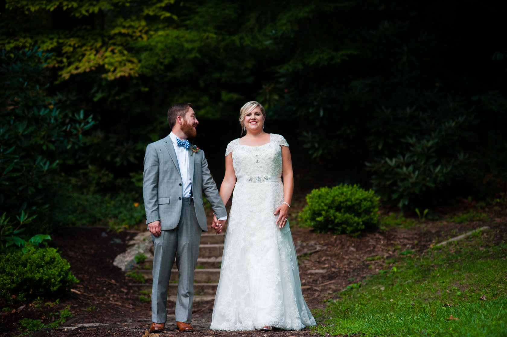 husband looks at his beautiful bride during couples portraits in the woods