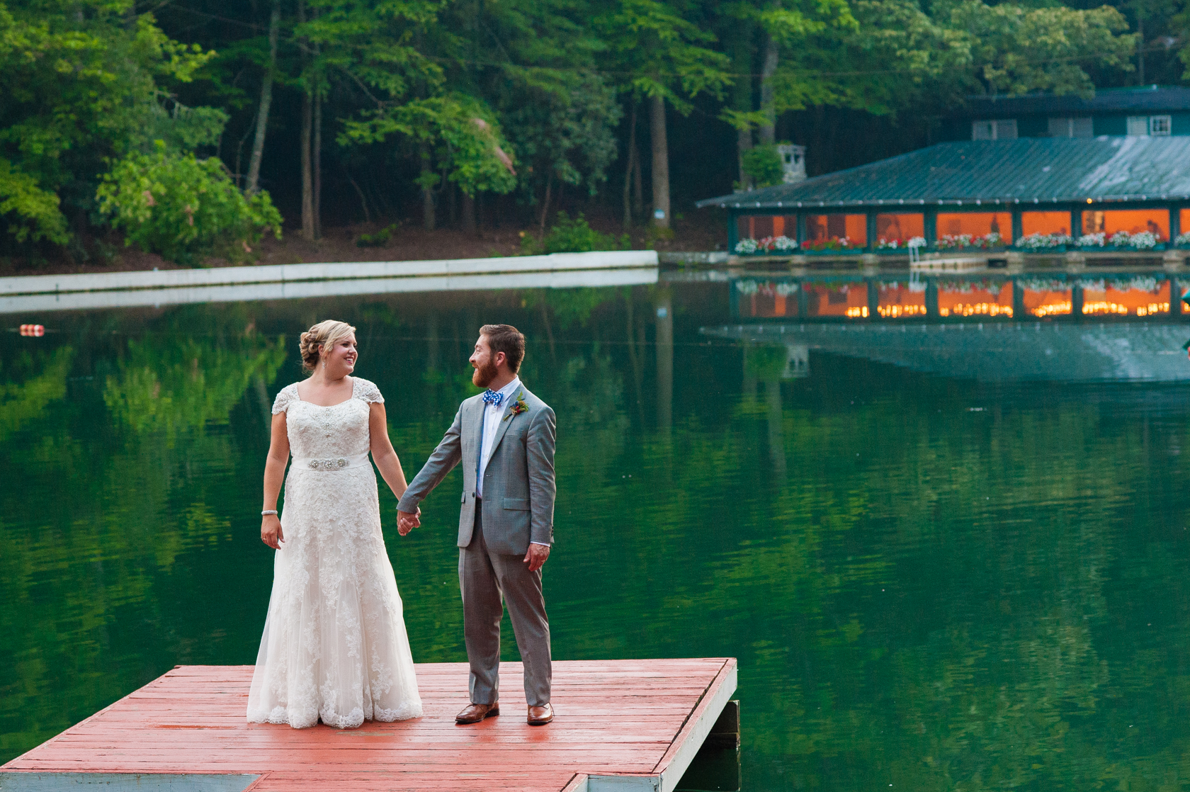 newly married couple holding hands during their summer camp wedding portraits 