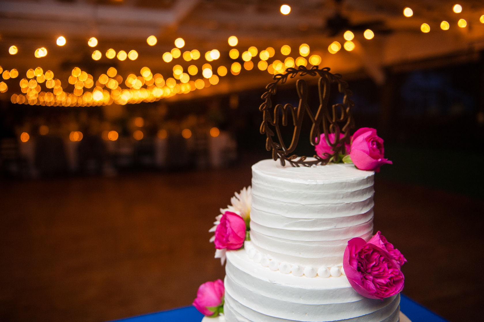 elegant wedding cake with real flowers was a beautiful addition to this summer camp wedding  