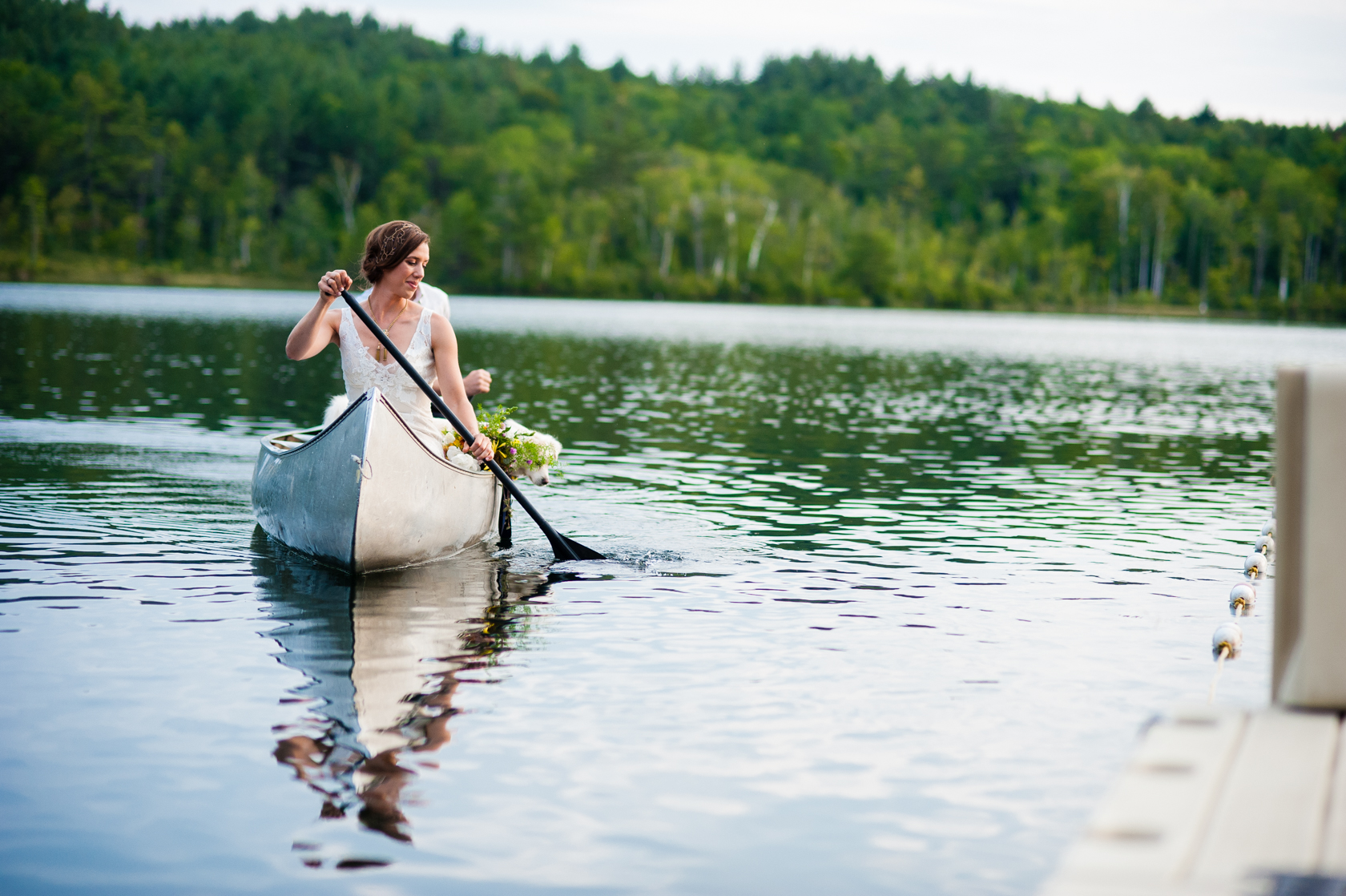 beautiful bride paddling a canoe on her wedding day