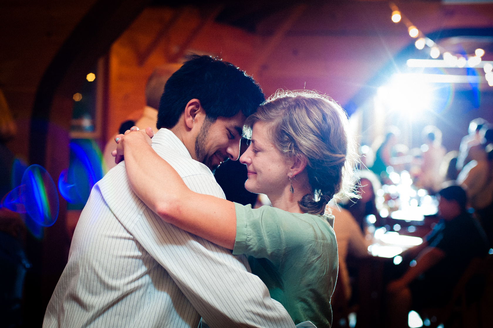 a young couple dancing during a summer camp wedding reception 