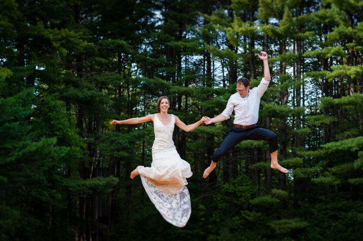 adventurous bride and groom jumping in the air on a big trampoline  on their wedding day