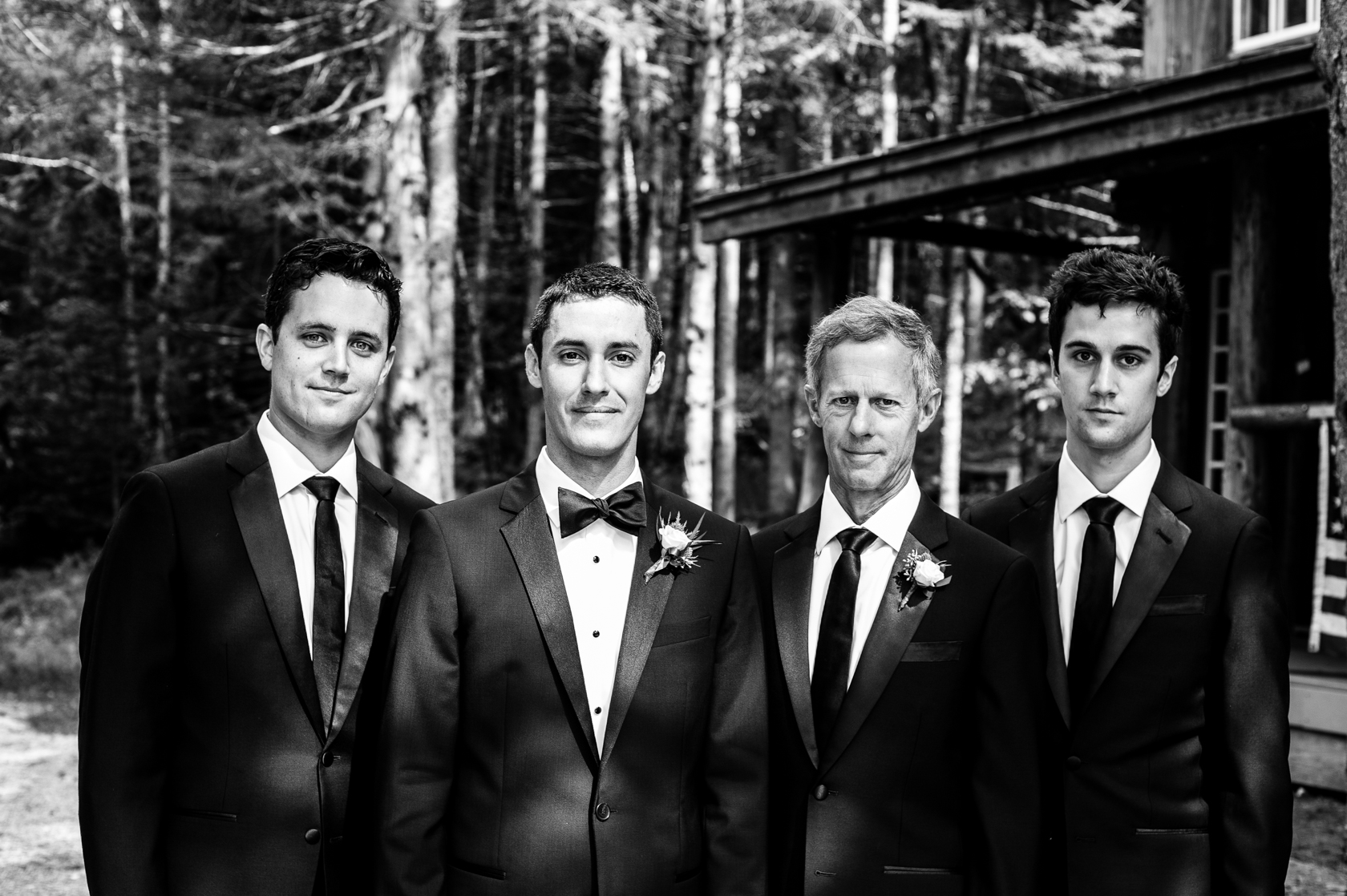 groom and his best men pose for a portrait in the woods