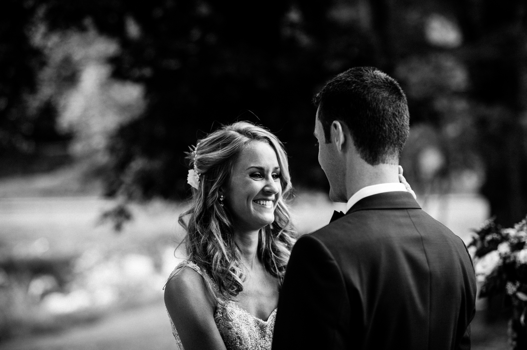 beautiful black and white image of bride smiling at her groom 