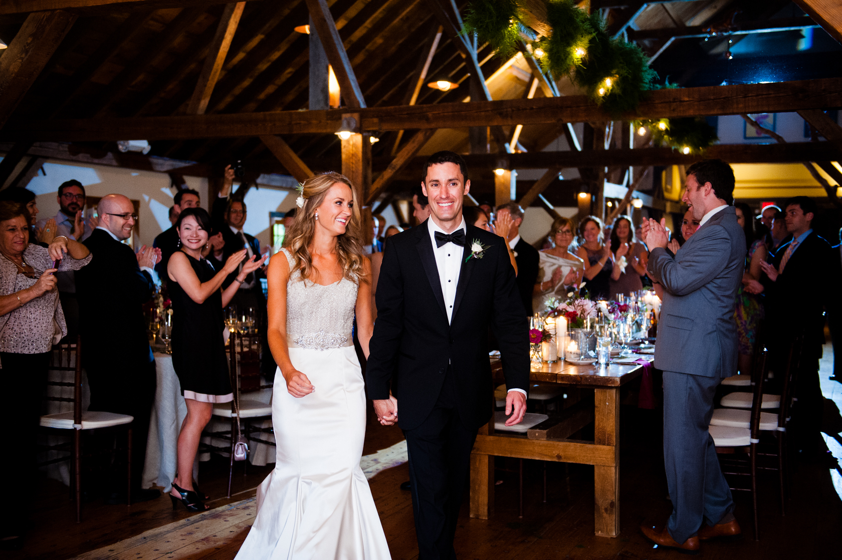 happy bride and groom enter their barn reception 