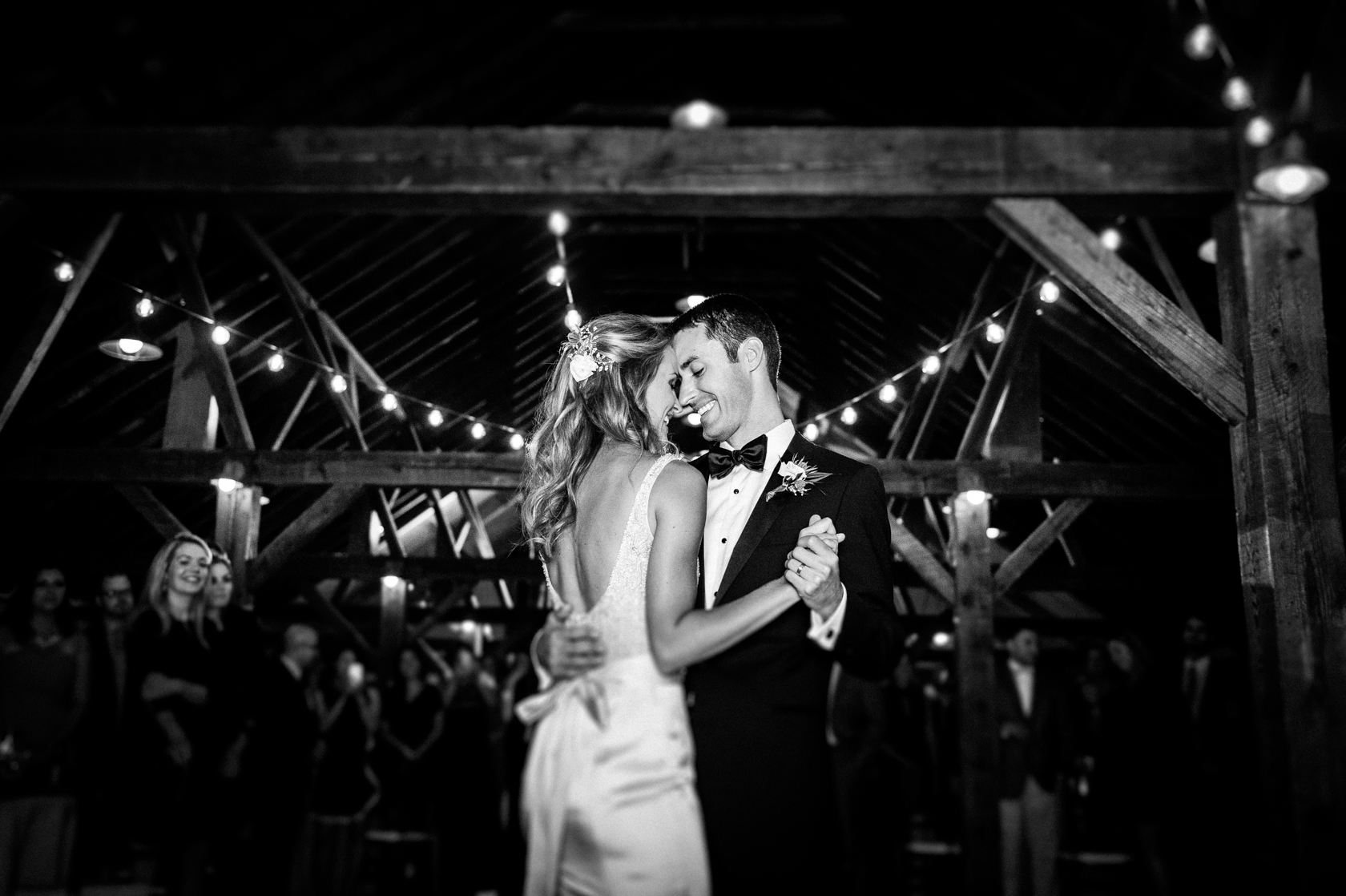 bride and groom perform their first dance underneath twinkling christmas lights 