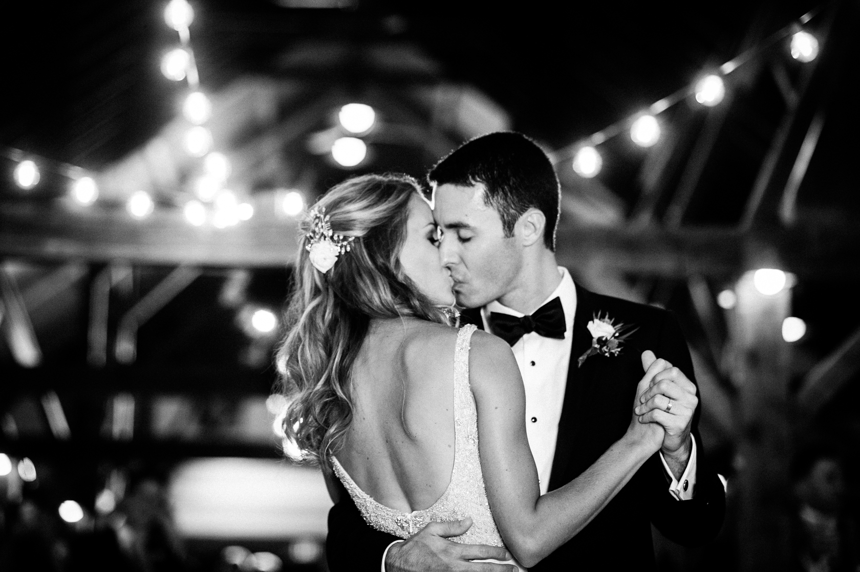 newly married couple kissing during their beautiful barn reception 