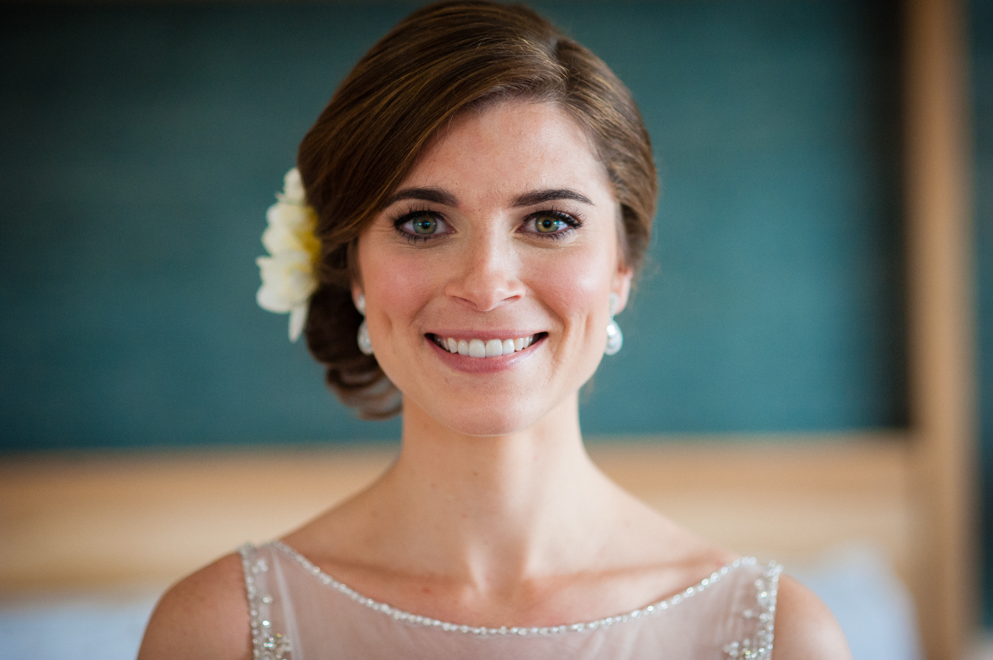 beautiful bride with a white flower in her hair smiling 