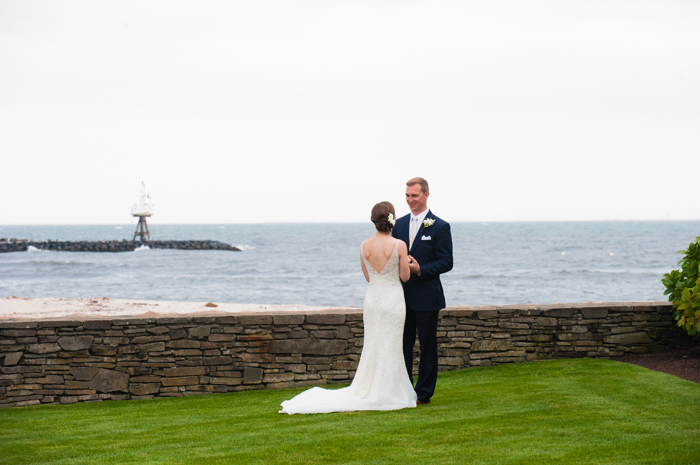 bride and groom looking at each other by the ocean 