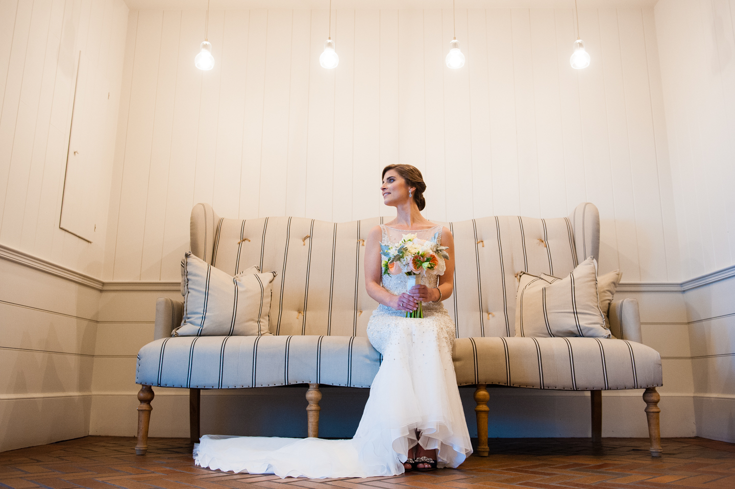 beautiful bride poses on the couch for a bridal portrait 