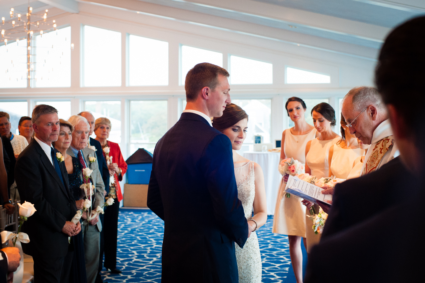 bride and groom hold hands during their ballroom ceremony 