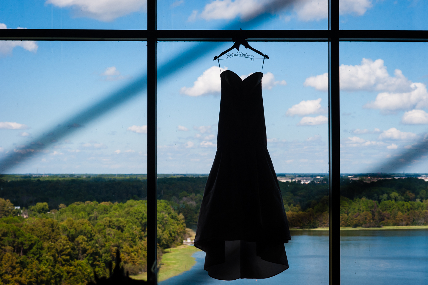 silhouette of wedding dress hanging in Disney contemporary resort window 