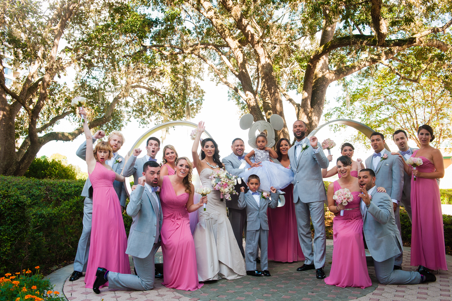 fun wedding party cheering with disney worlds mickey mouse statue