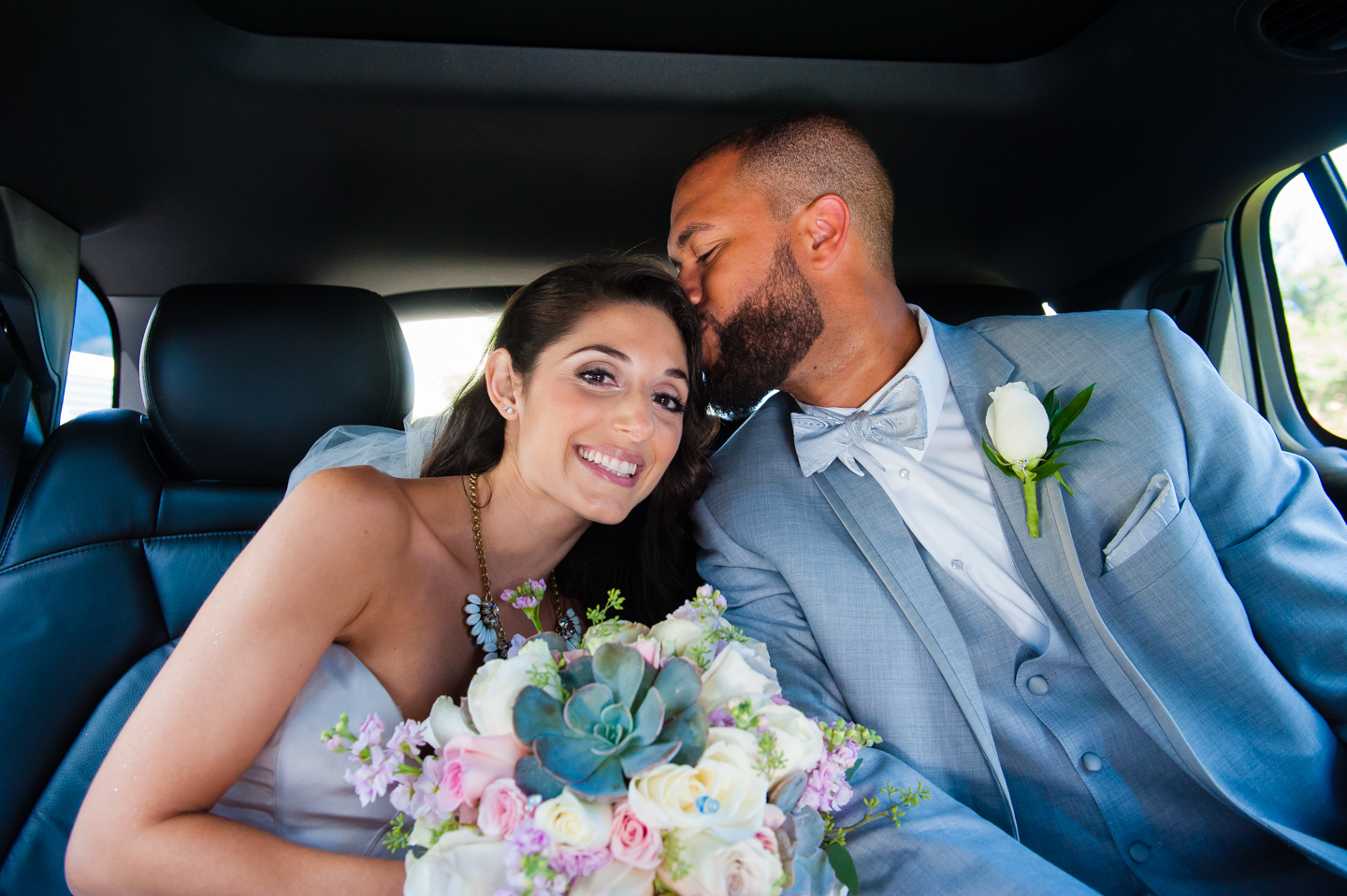 beautiful bride gets kiss on the head from her prince charming