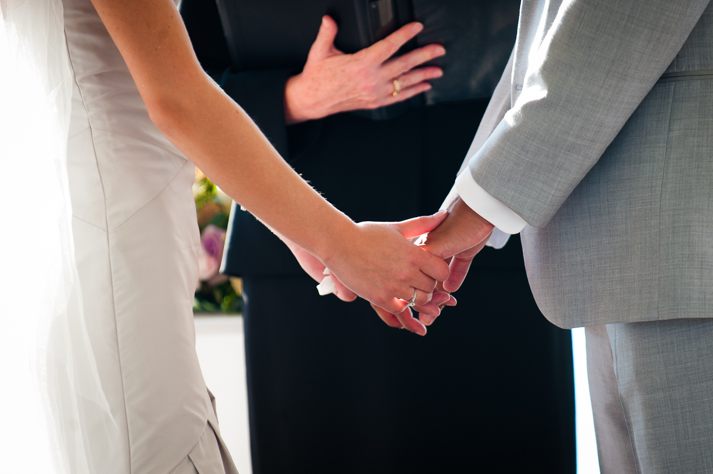 bride and groom hold hands during their wedding ceremony 