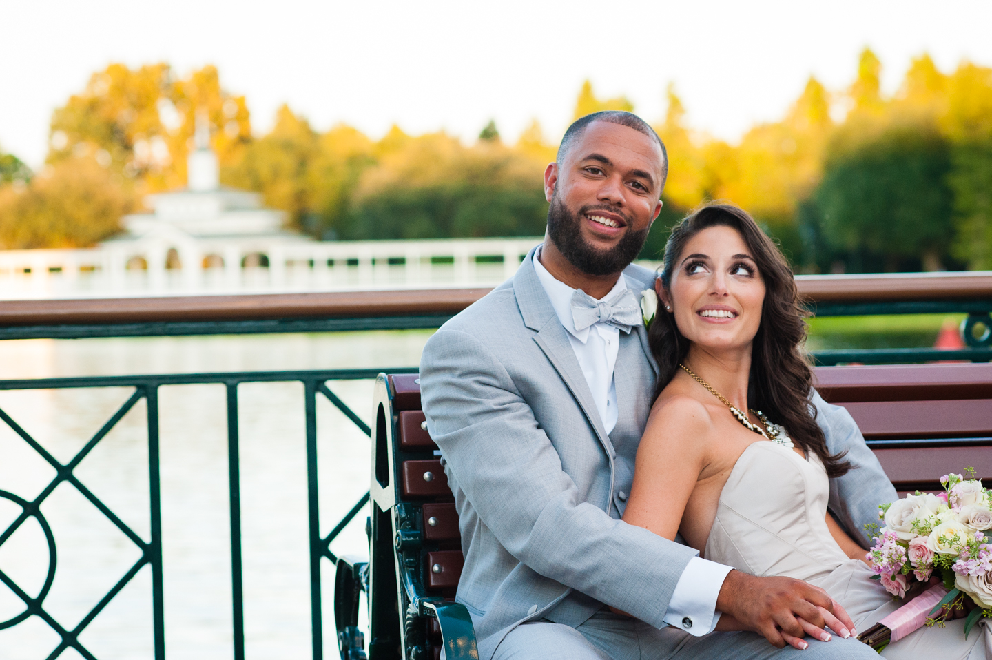 adorable newly married couple sits on bench on atlantic  boardwalk 