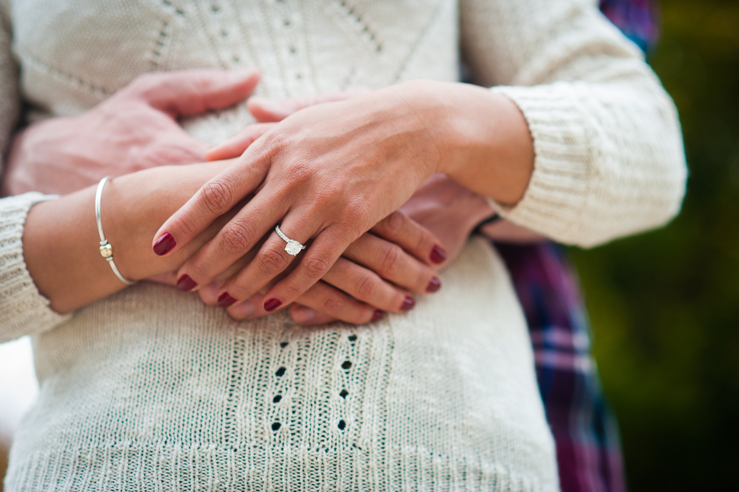 beautiful engagement ring against white sweater 