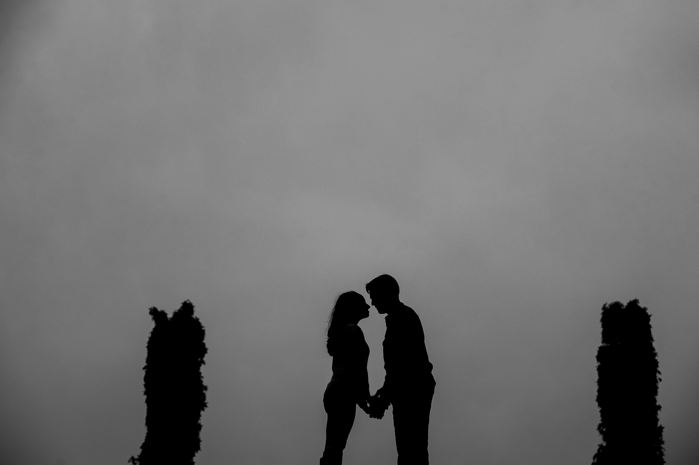 black and white moody silhouette of couple kissing 