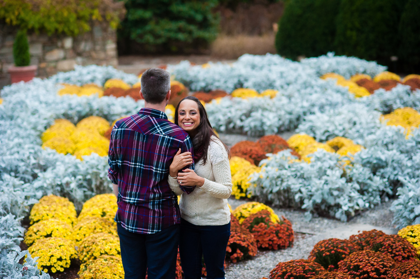 young couple in colorful gardens during engagement pictures nc arboretum 