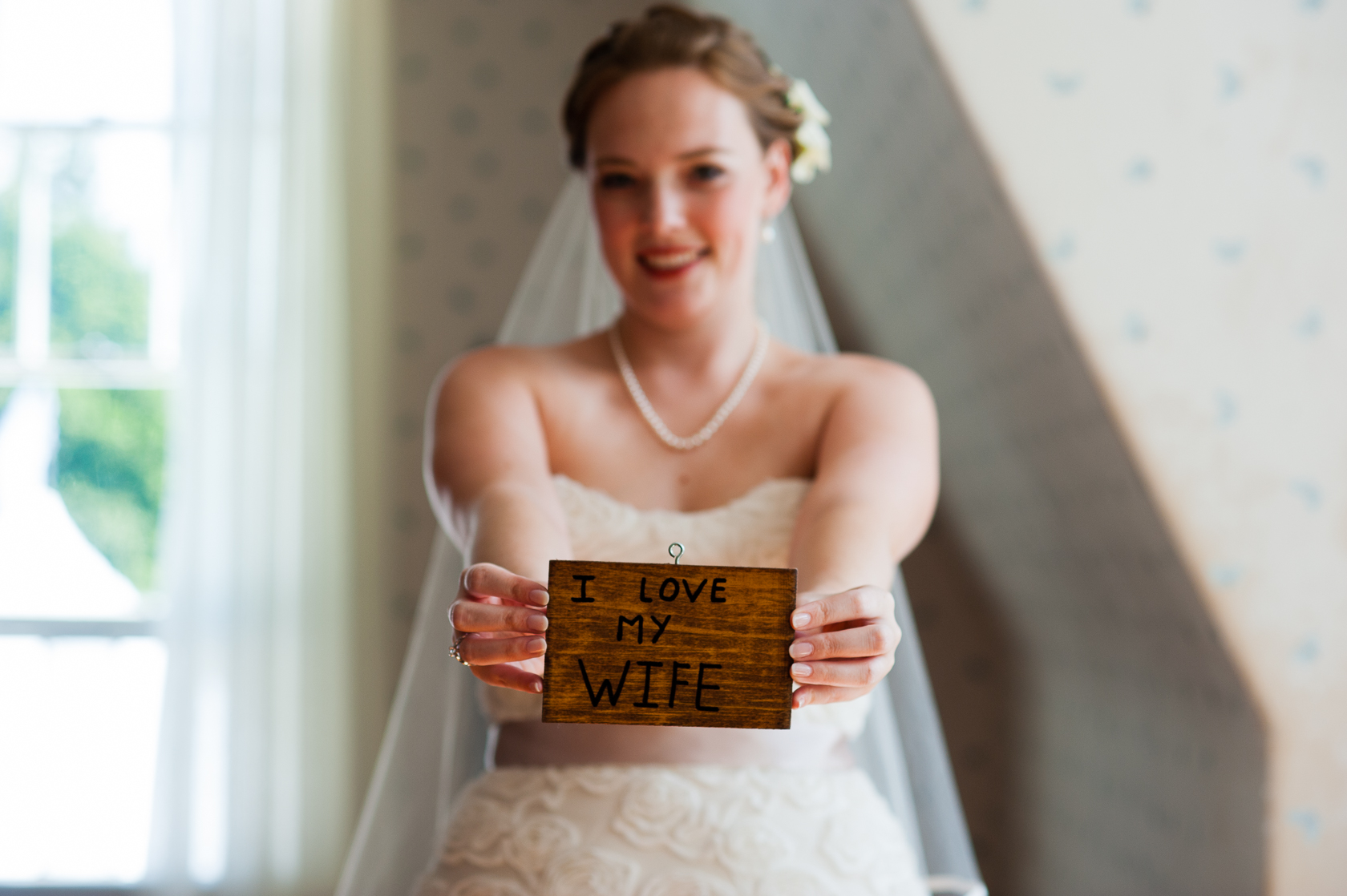 beautiful bride holding up wedding day present from groom 