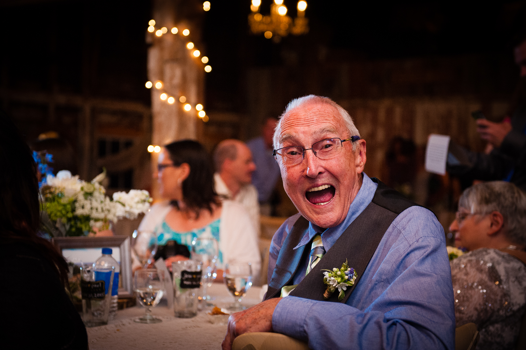 brides grandpa smiles during barn wedding 