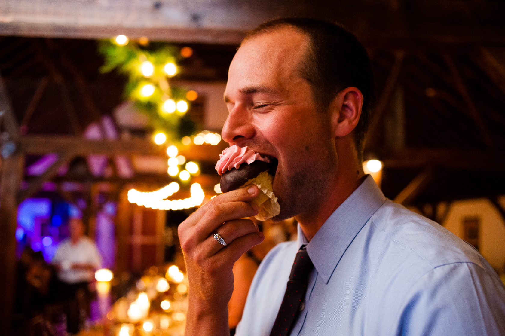asheville barn wedding photo of goofy guest with cupcake