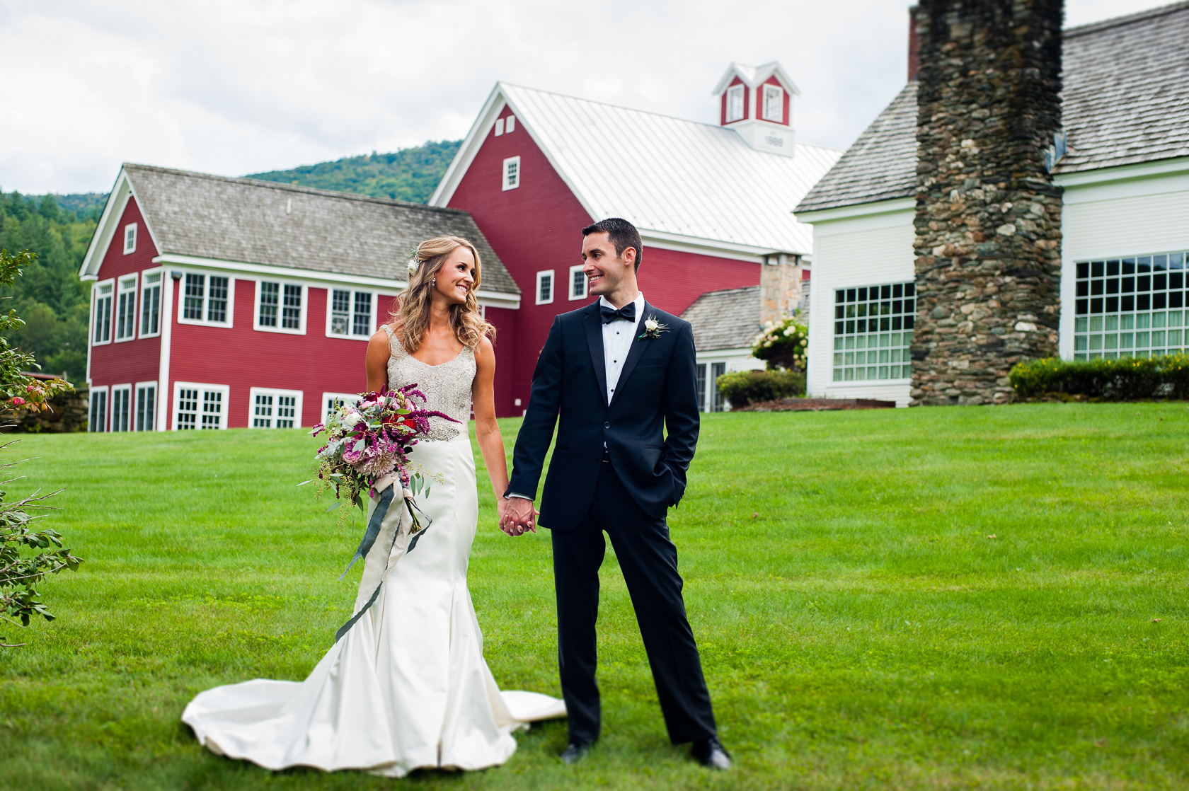 couple poses in front of barn during asheville farm wedding 