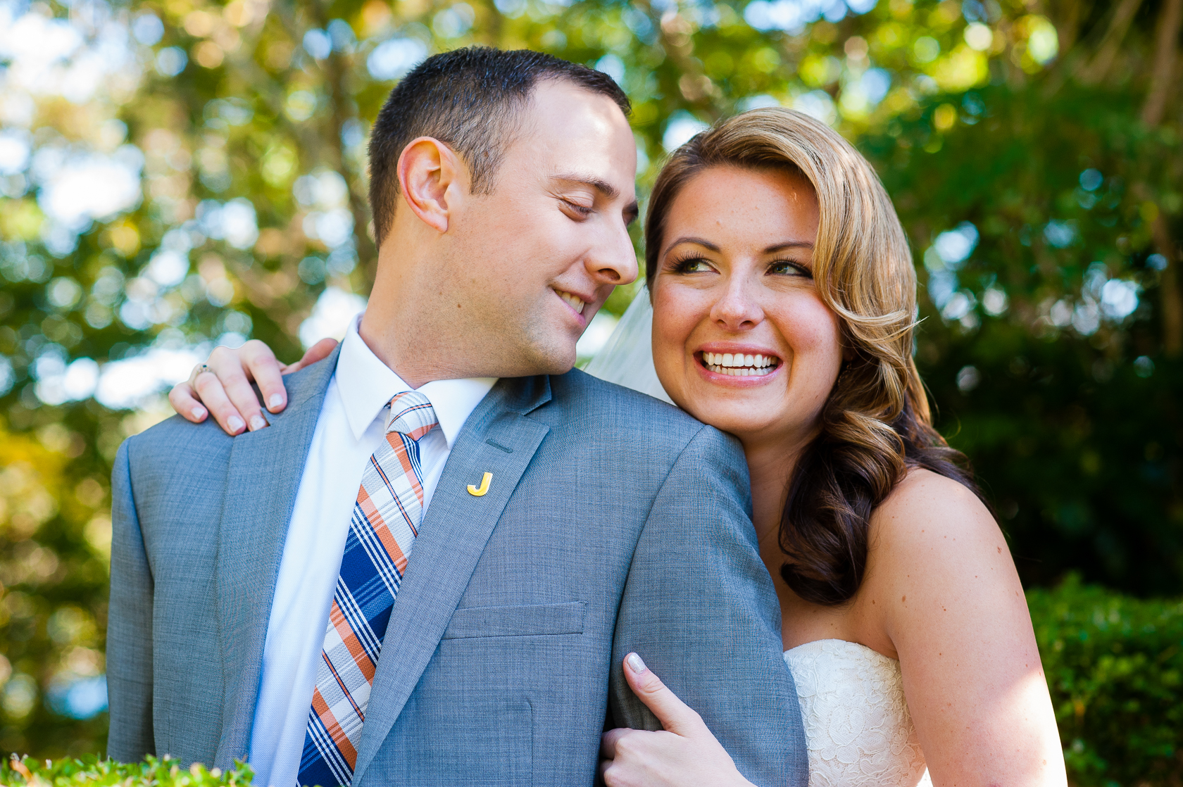 groom gives his beautiful bride kiss on cheek 