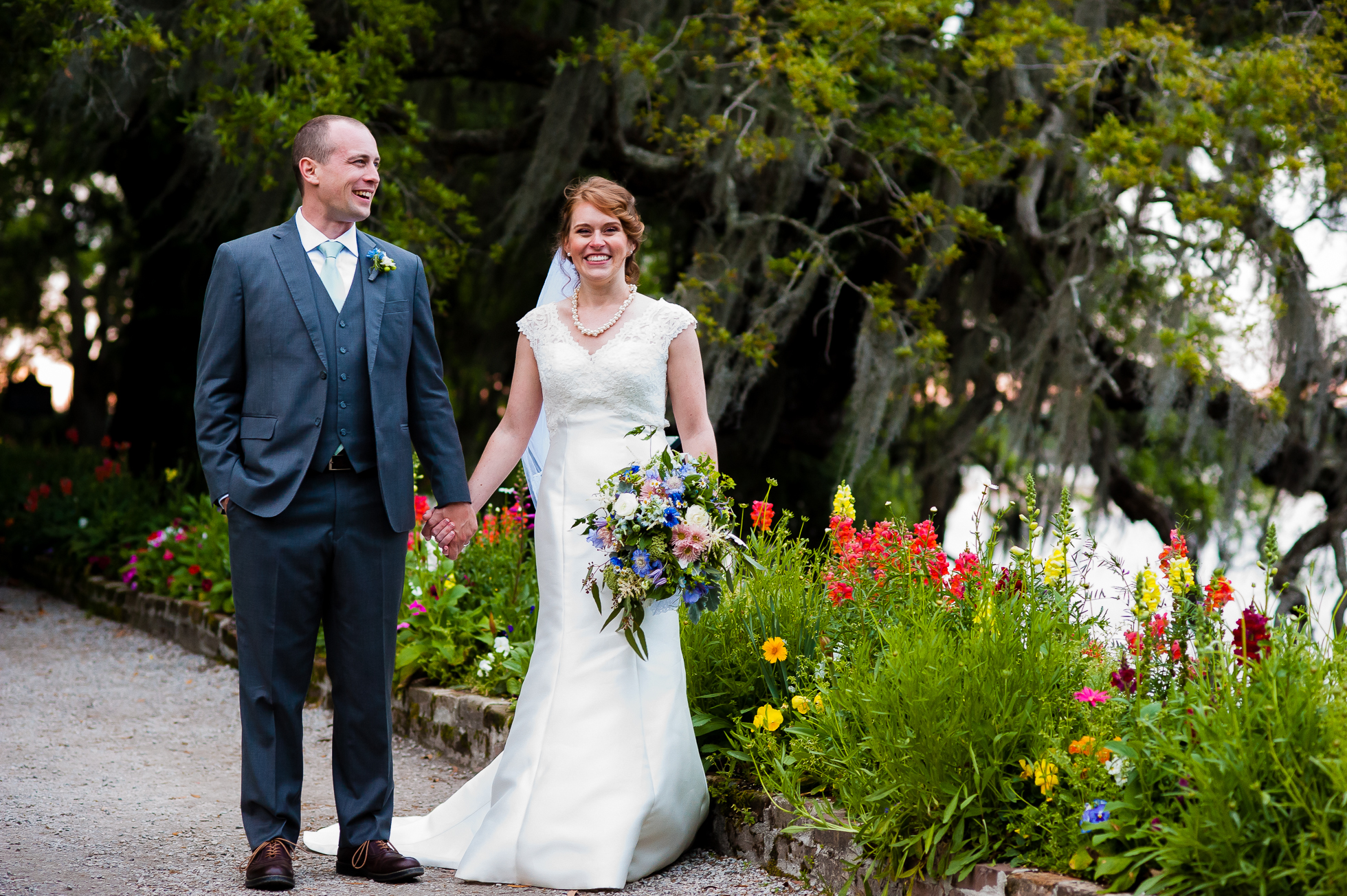 bride and groom holding hands in the gardens at Magnolia plantation on their wedding day