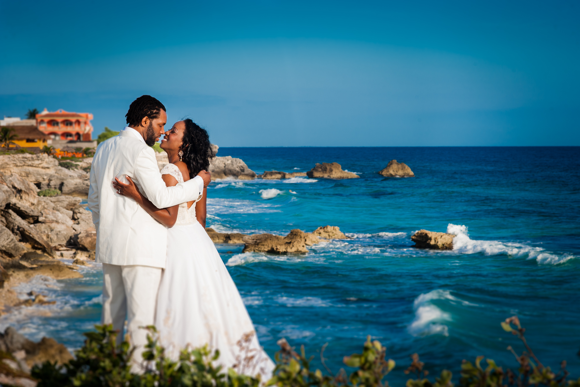 isla mujeres wedding bride and groom kiss on rocky coastline