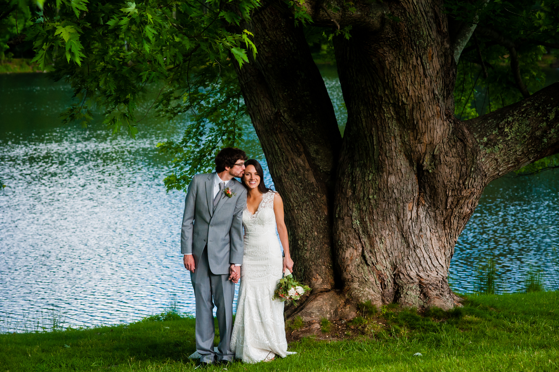 bride and groom kiss under gorgeous oak at lake eden 
