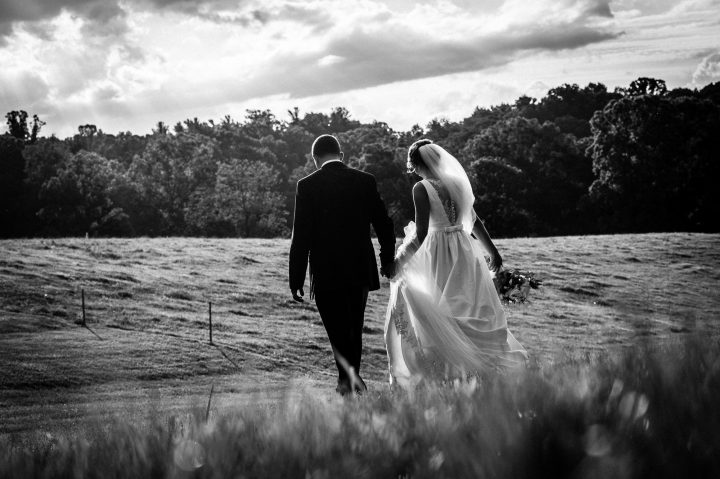 bride and groom walk hand in hand at the biltmore estate