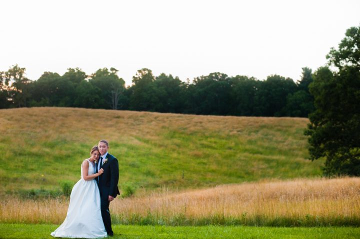 bride and groom in the field by lioncrest