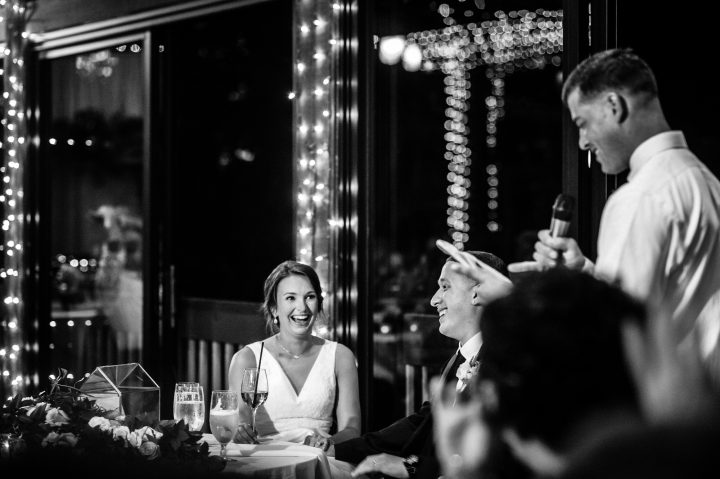 bride and groom enjoy the toasts by best man and maid of honor