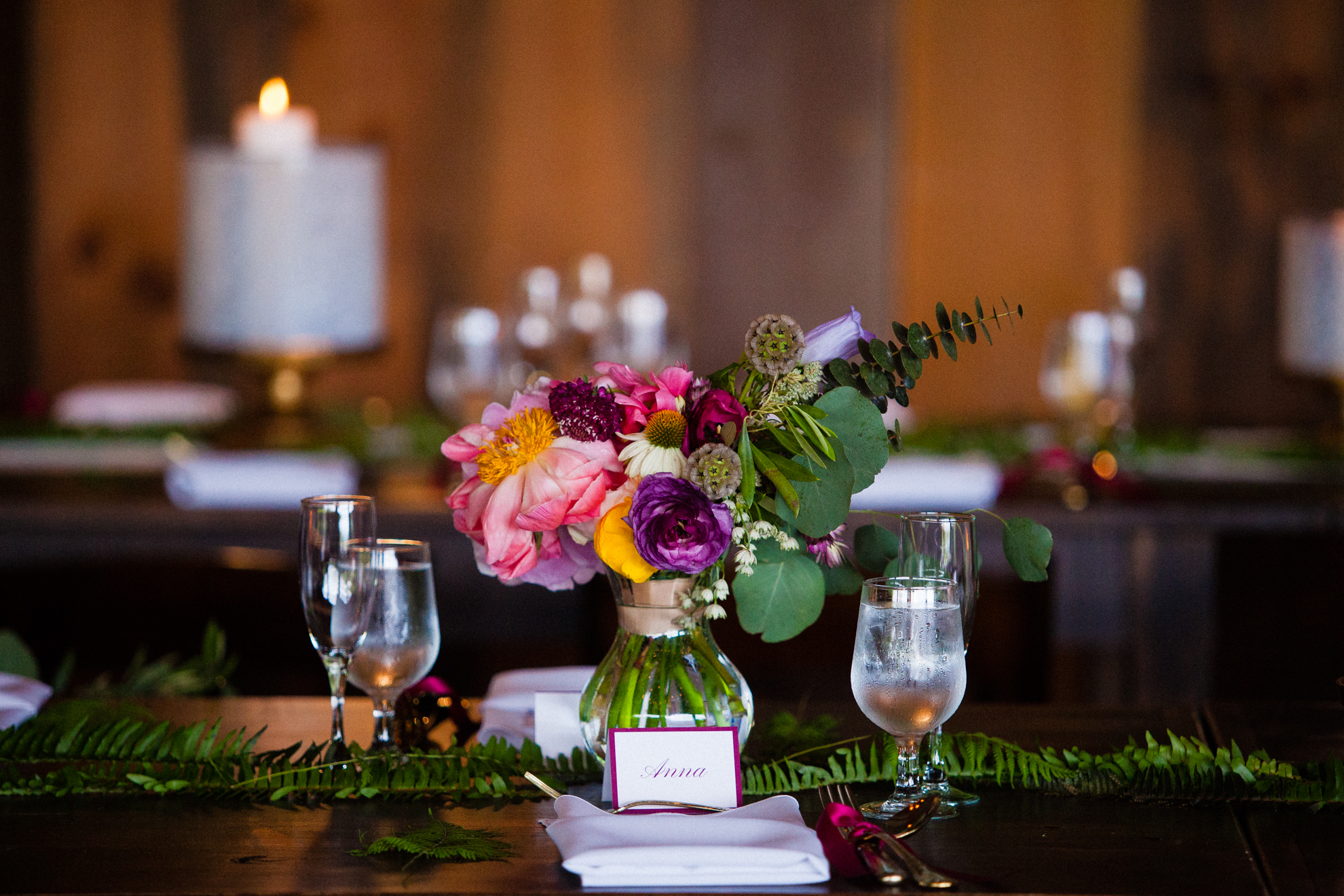 brightly colored flowers adorned the rustic wooden tables during this summertime wedding in the mountains