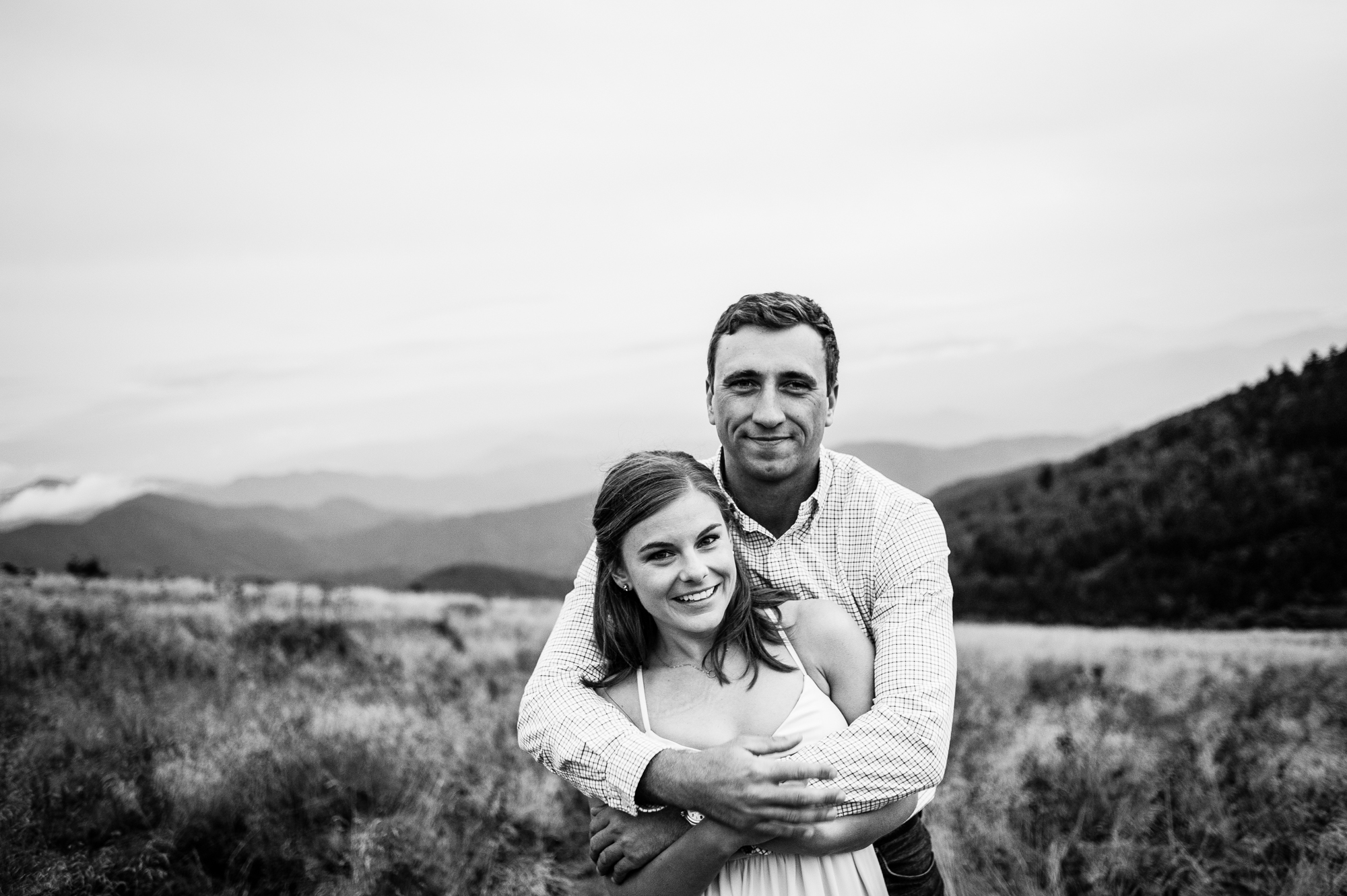 adorable couple poses for a photo during their engagement session in the mountains