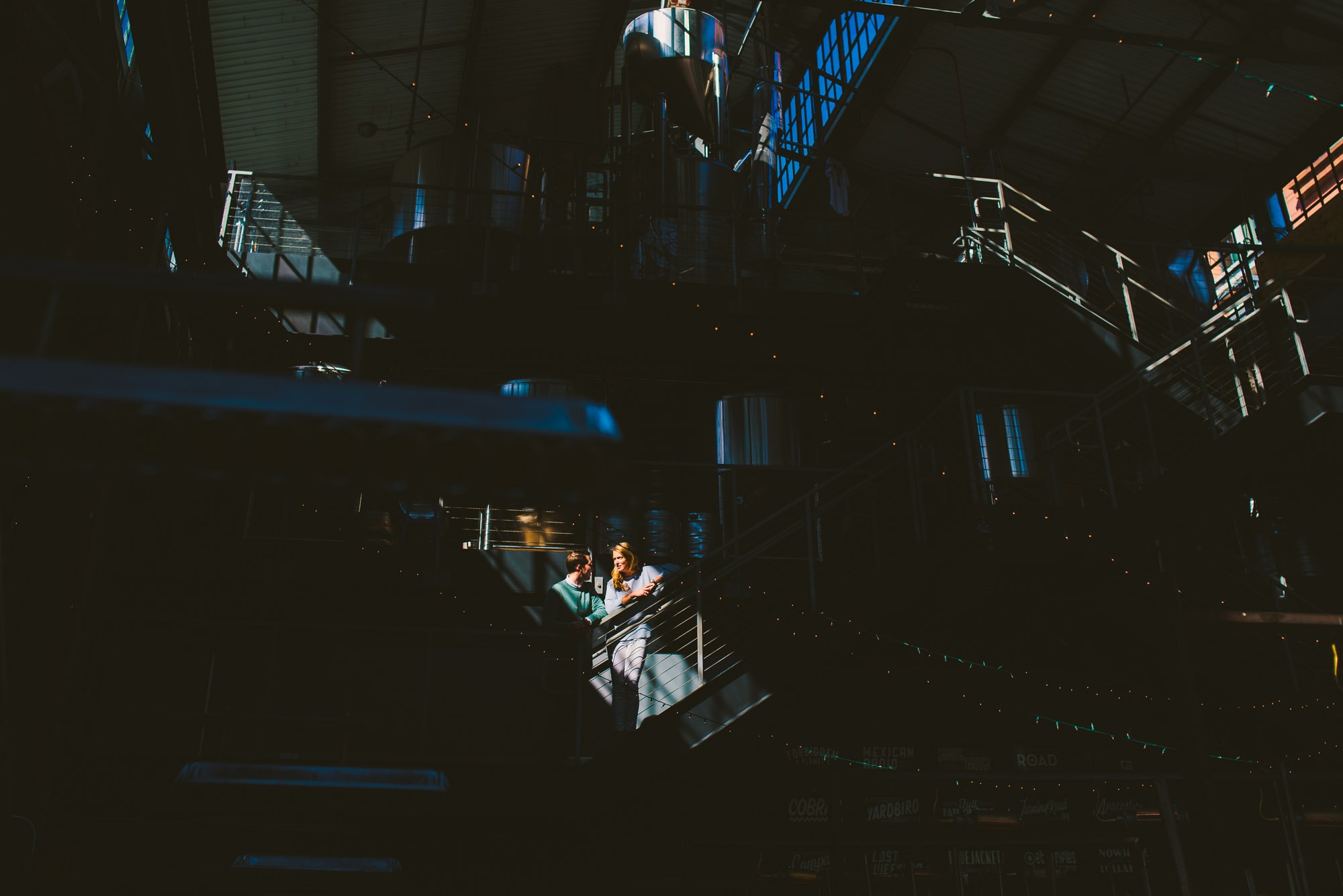 Dramatic light highlights couple during their brewery engagement session 