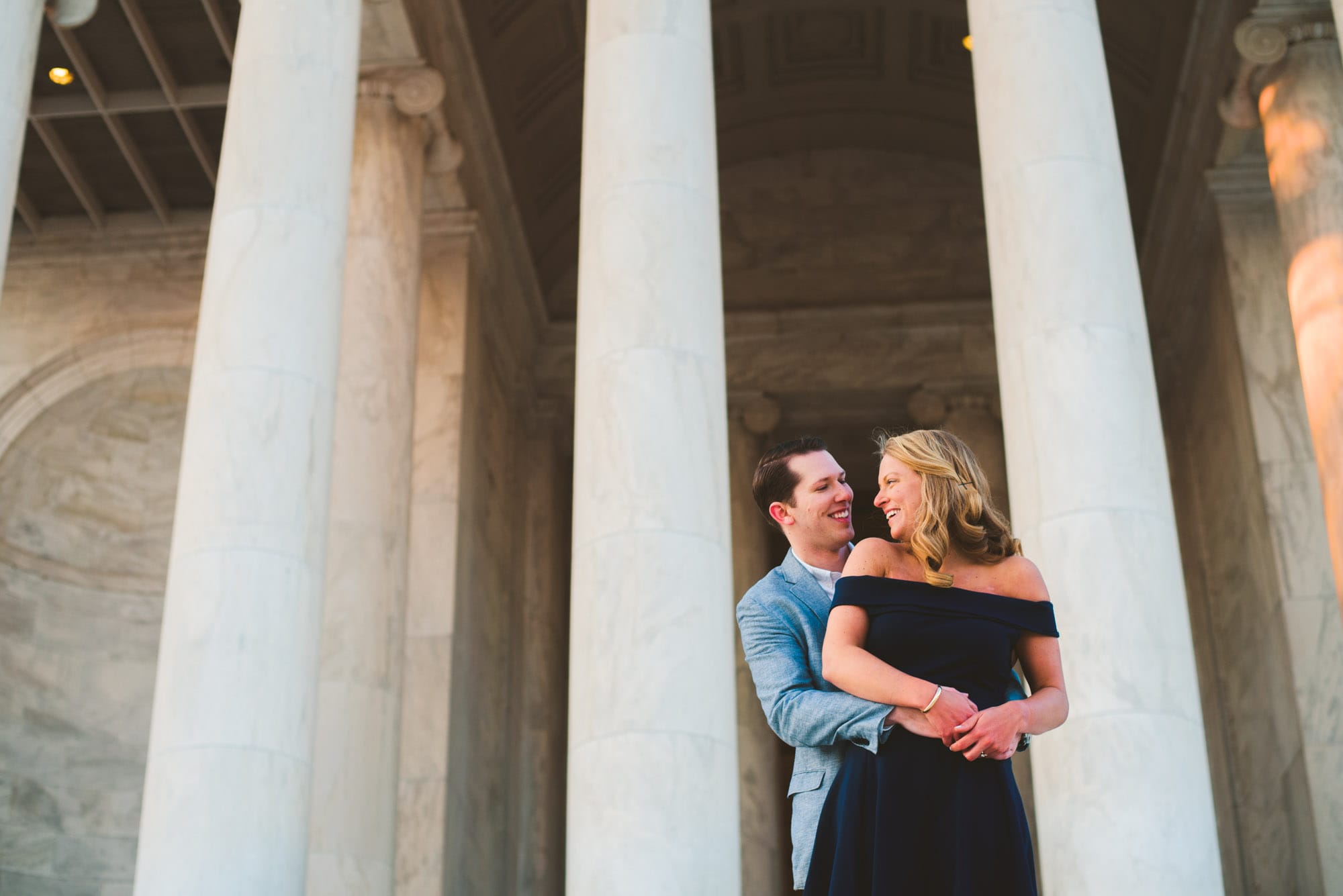 couple laughing in front of the Jefferson memorial during their engagement session in washington DC.