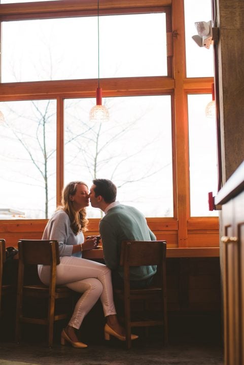 couple warming up inside a cute coffee shop during their winter engagement session in DC 