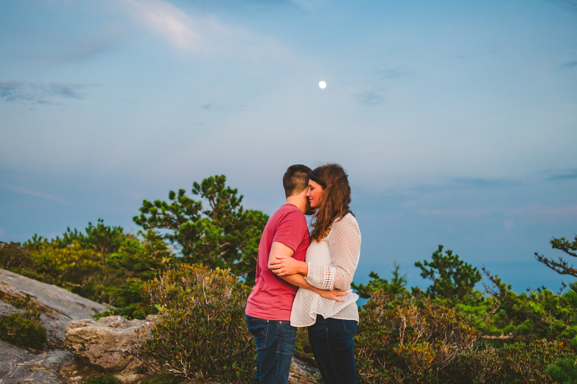 Couple embraces during mountaintop engagement 