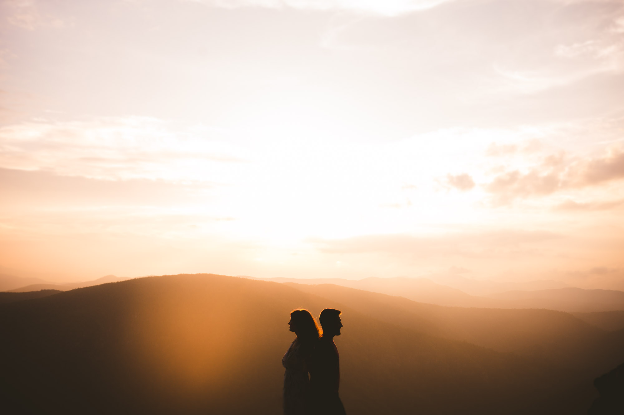 Gorgeous sunset silhouette of couple during Linville gorge wilderness engagement session 