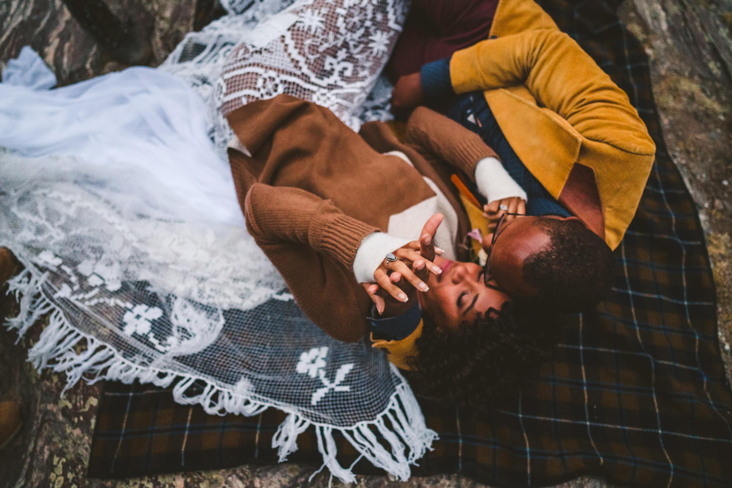 Couple snuggling on a blanket during their Alaska elopement. 