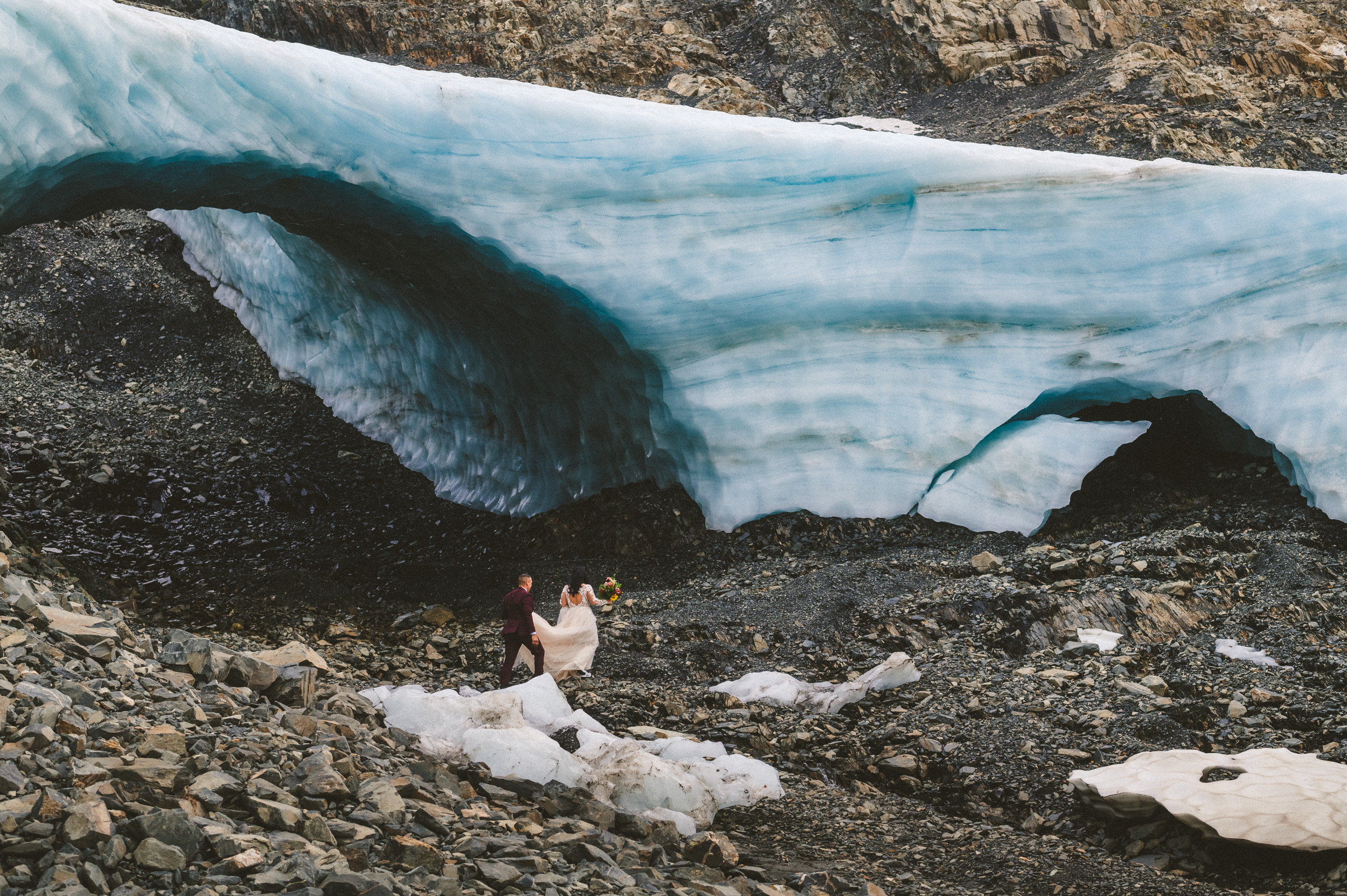 Bride and groom explore near big alaska ice cave